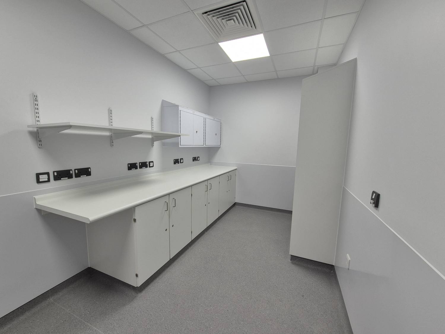 Clinical room fit-out with worktop and shelving